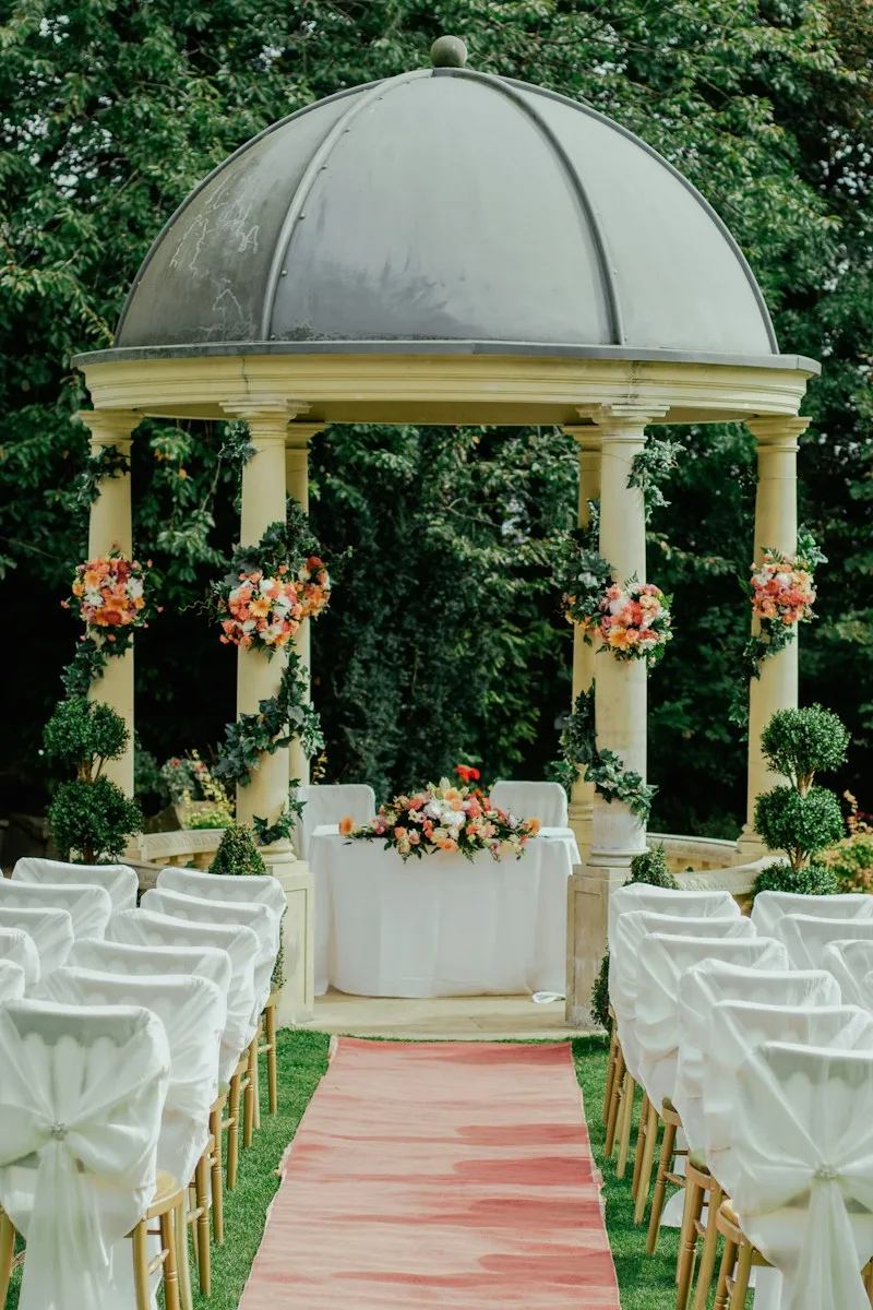 A flower-covered garden pavilion prepared for a wedding ceremony