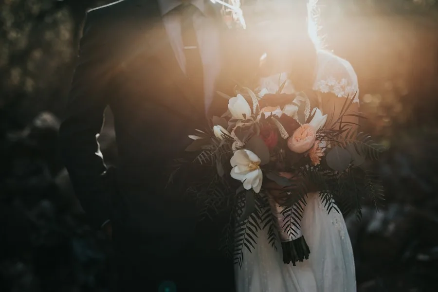A bride and groom embracing in warm afternoon light